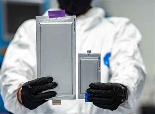 Lab technician holding two solid-state battery pouch cells, highlighting their compact, lightweight form factor
