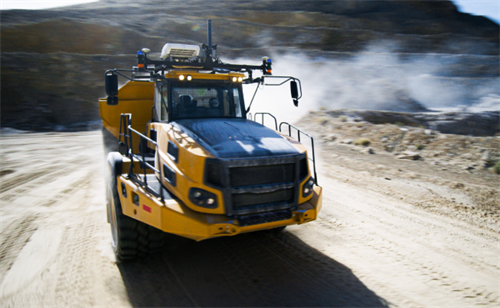 An autonomous mining truck operating on a dusty quarry road, representing closed-environment industrial autonomous driving.