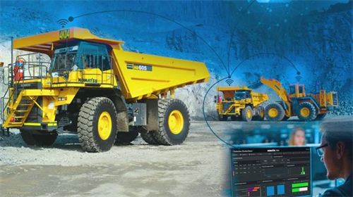 A connected fleet of Komatsu mining trucks monitored from a control room, showing how industrial autonomy enables operational efficiency and profitability